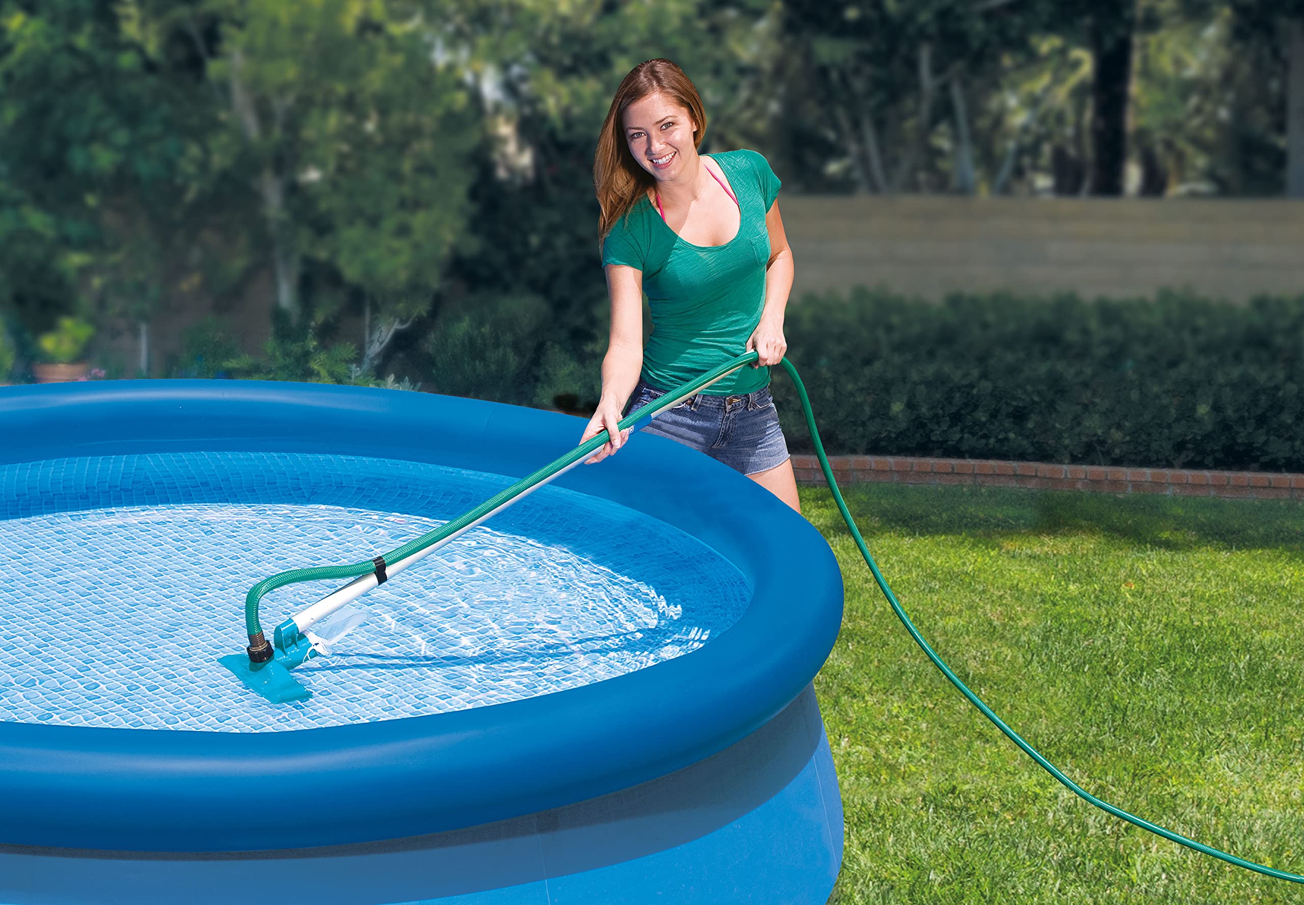 Woman vacuuming an Easy Set inflatable-ring above-ground pool with the Intex maintenance kit
