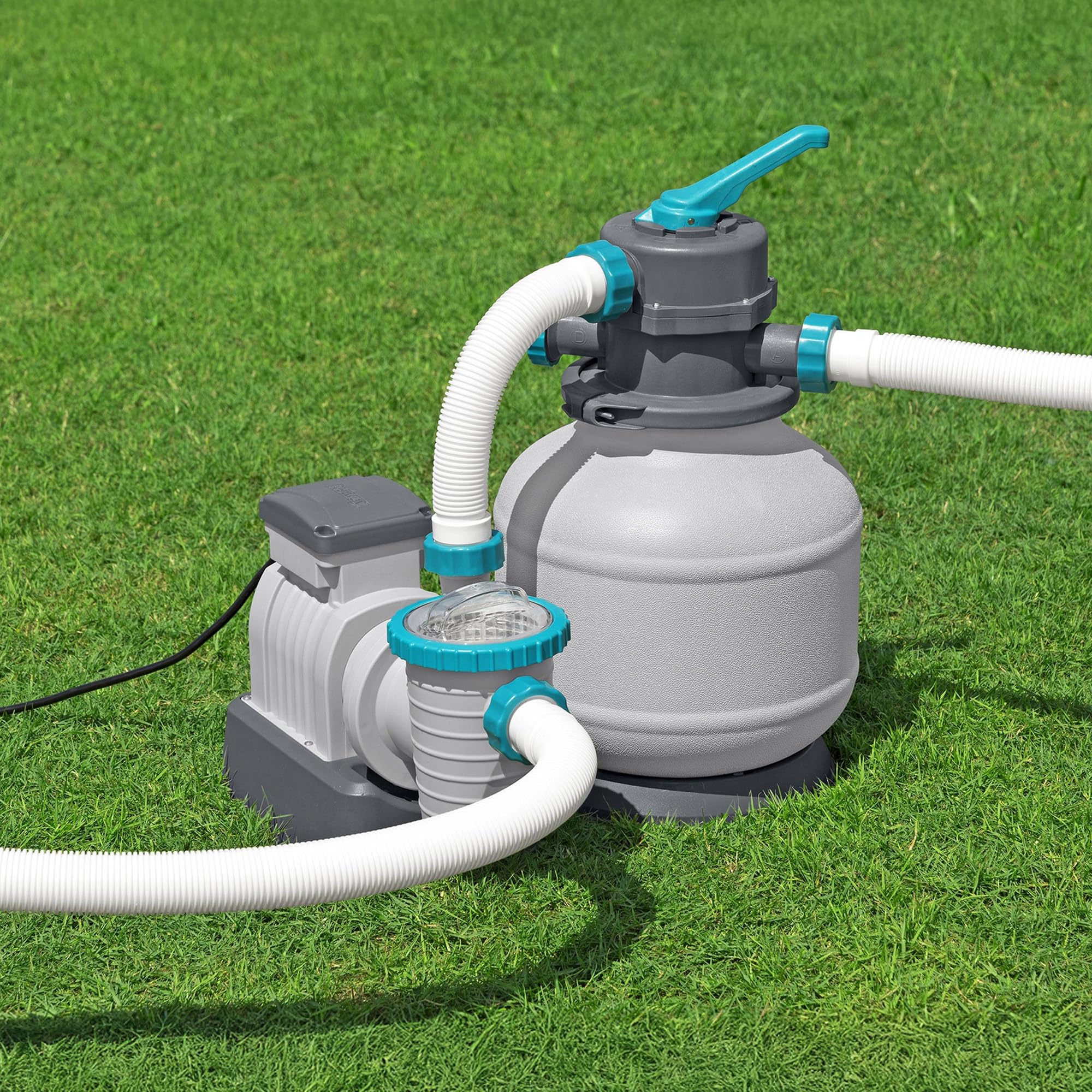 Bestway sand filter pump connected with hoses on a lawn