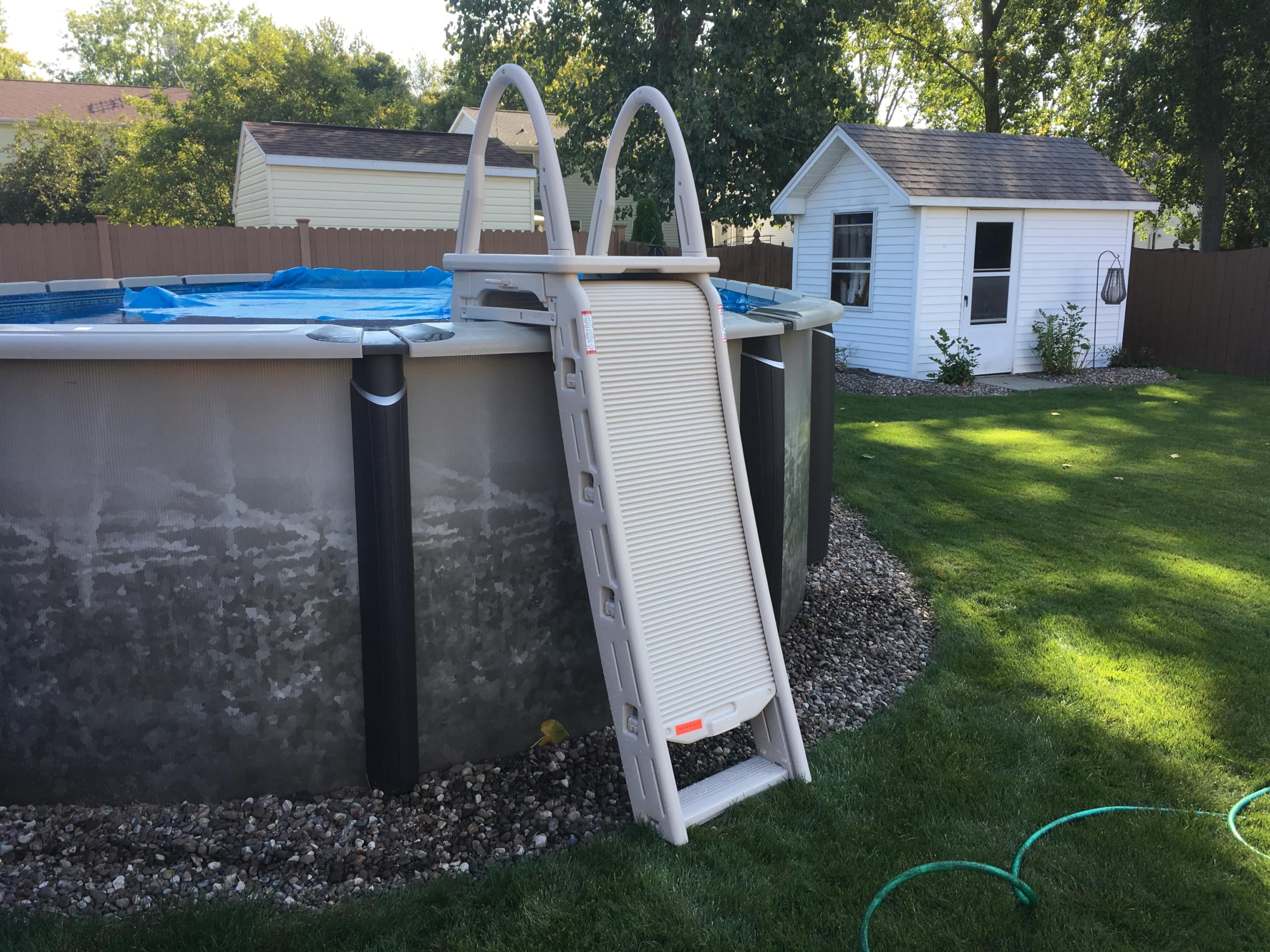 Confer Roll-Guard ladder on an above-ground pool with the roll-guard barrier rolled down in the closed, secured position
